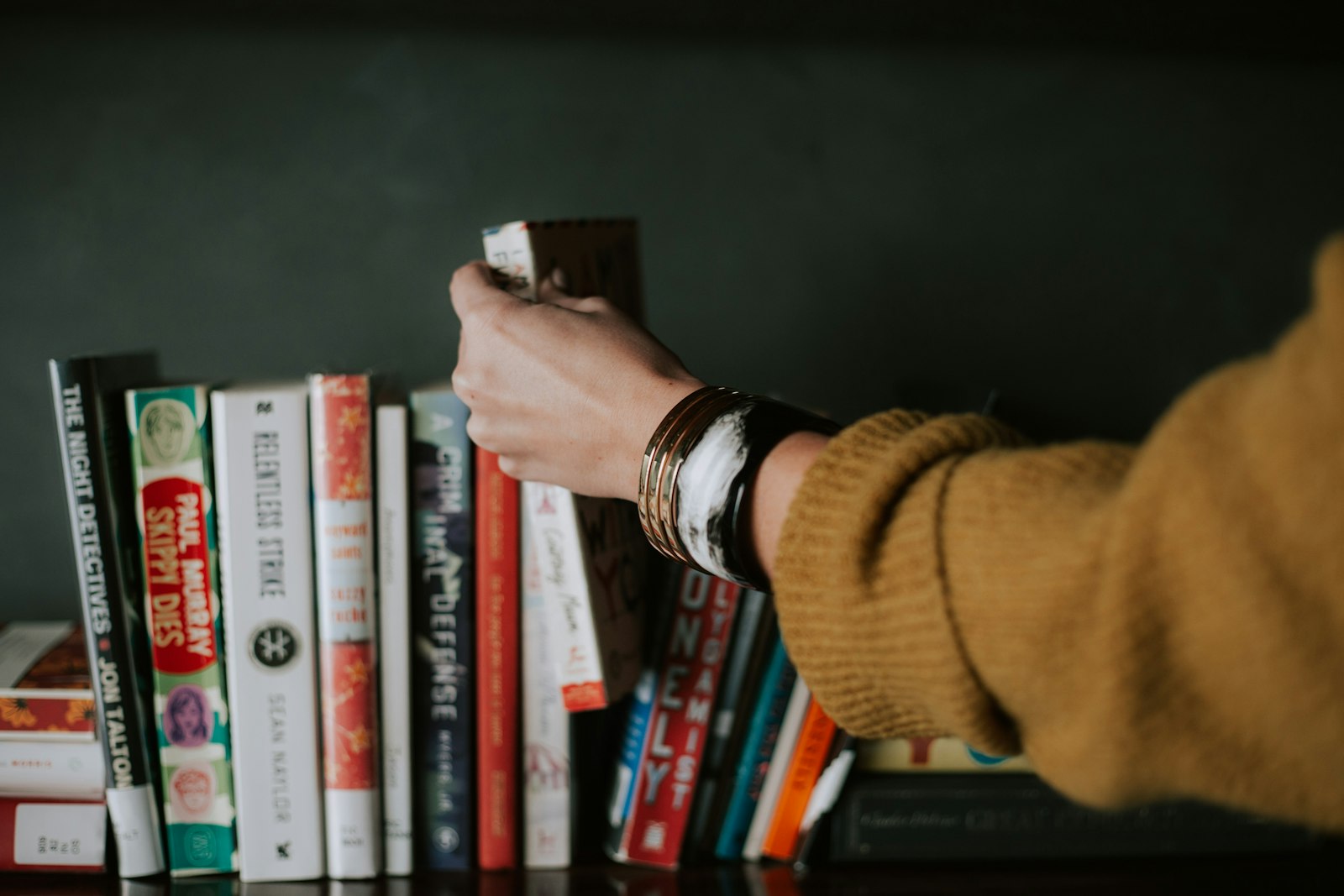 Hand pulling a book from a shelf